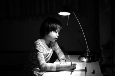 Girl studying in darkroom at home