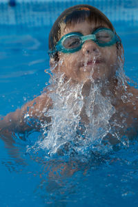 Close-up of shirtless boy swimming in pool