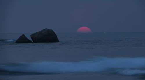 Scenic view of rocks in sea against sky