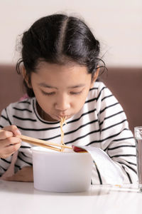 Cute girl eating food at home