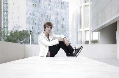 Full length of young man sitting in building