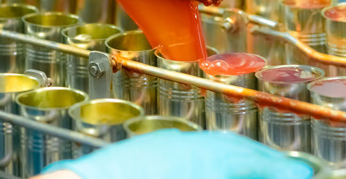 Canned fish factory. food industry. machine filling red tomato sauce into sardine can food factory