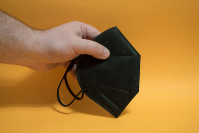 Close-up of hand holding black background