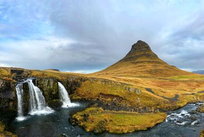 Scenic view of waterfall against sky