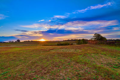 Scenic view of field against sky during sunset