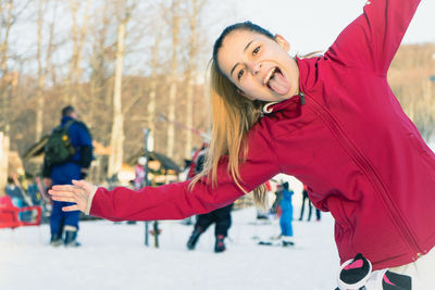 Portrait of teenage girl sticking out tongue at ski resort