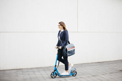 Active businesswoman riding scooter in the city