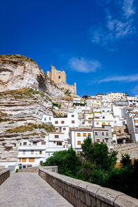 View of buildings in town against blue sky