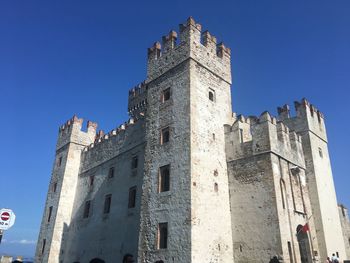 Low angle view of historic building against blue sky