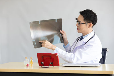 Midsection of man using smart phone on table