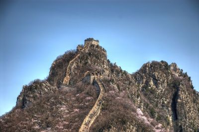 Low angle view of rock formation against clear blue sky