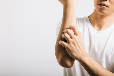 Low section of woman gesturing against white background