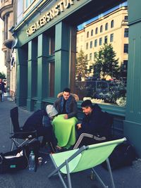 People sitting on street in city