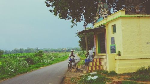 Rear view of people on street against sky