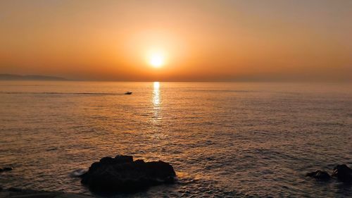 Scenic view of sea against orange sky