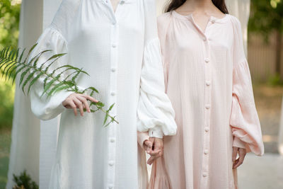 Midsection of women standing with plant