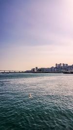 View of city by sea against sky