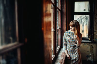 Young woman standing by window