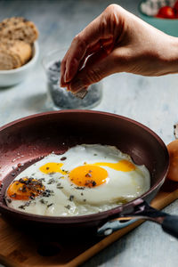 Close-up of person preparing food in frying pan