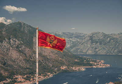 Montenegrin flag against sea and mountains