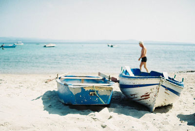 Nautical vessel on beach against clear sky