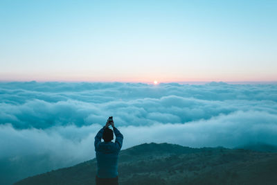 Silhouette of woman standing on landscape at sunset