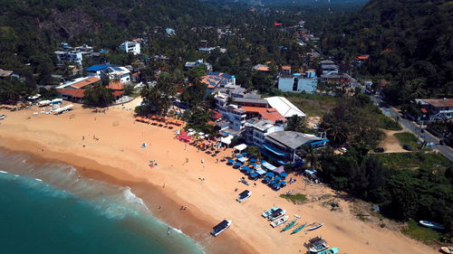 High angle view of crowd on beach by buildings in city