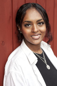 Portrait of young woman against wall