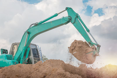 Bulldozer on land against sky