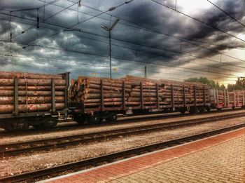 Train on railroad track against cloudy sky