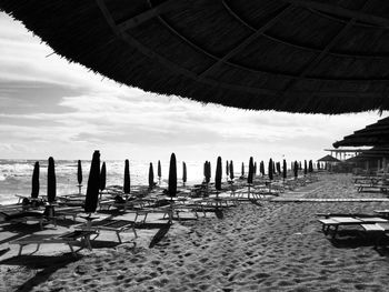 Panoramic view of wooden posts on beach against sky