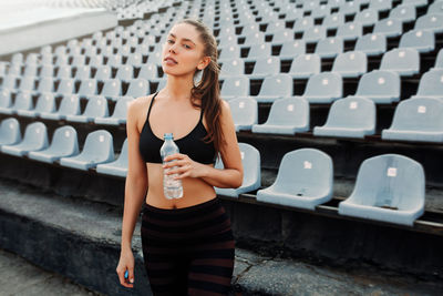 Happy woman standing against wall