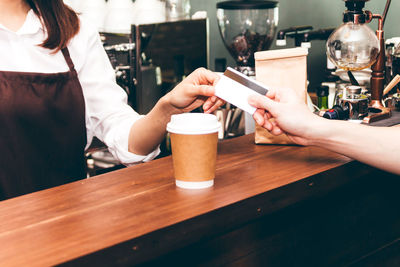 Midsection of woman having coffee at restaurant