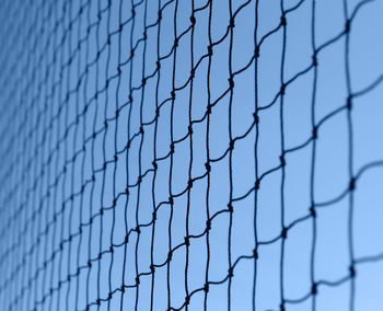 Close-up of fence against blue sky