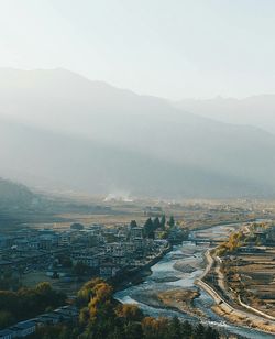 Aerial view of sea and cityscape against sky