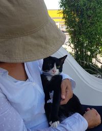 Midsection of person with cat sitting on sofa