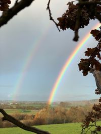 Rainbow over landscape against sky