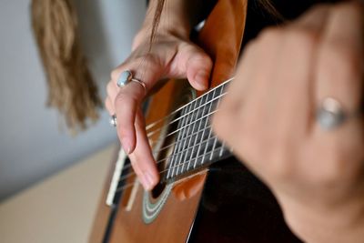 Midsection of man playing guitar