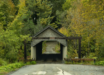 Covered bridge amidst trees in forest