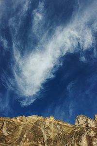 Low angle view of mountain against blue sky