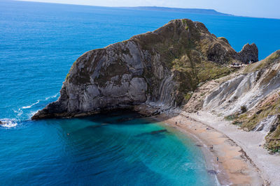 Scenic view of sea and rocks against blue sky