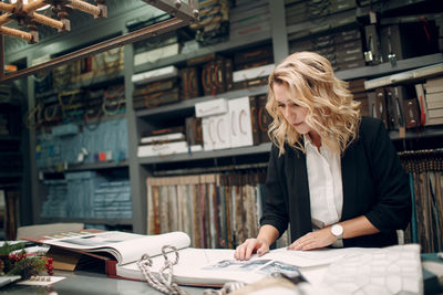 Woman reading book at table