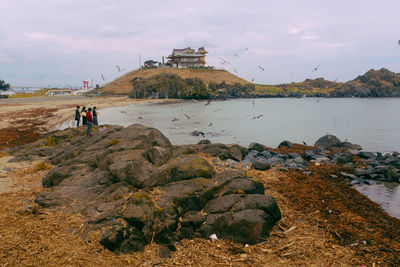 People on beach against sky