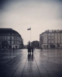 Rear view of people walking on street in city