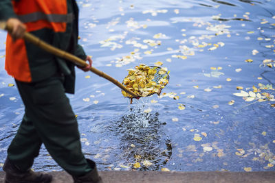 Low section of man cleaning water in lake