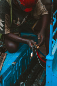 A local electrical engineer repairing  a bajaj in his garage