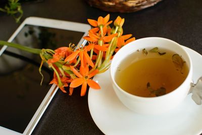 Close-up of herbal tea and phone on table