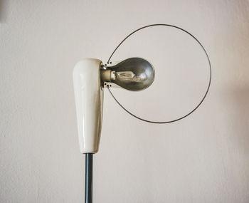 Close-up of light bulb against wall