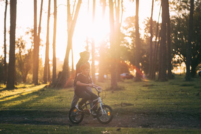 Mother assisting son while riding bicycle