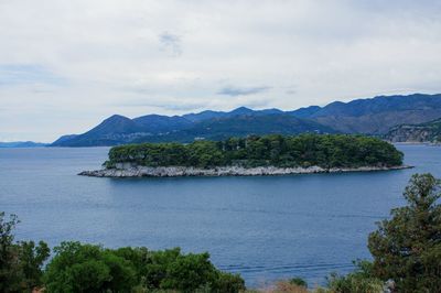 Scenic view of sea and mountains against sky